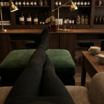 Entspannte Szene bei der Fußpflege: Beine auf einer Samt-Ablage, daneben Kaffee für zwei Personen. Symbolisiert Mädelszeit und Selbstfürsorge.